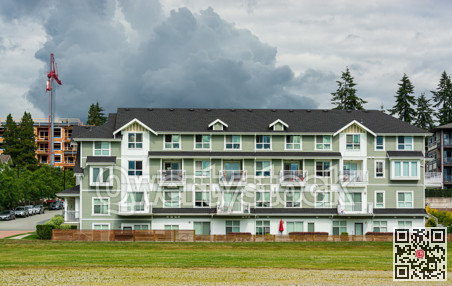 New residential low-rise building on cloudy sky background