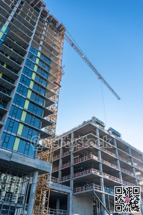 High-rise buildings under construction on blue sky background.