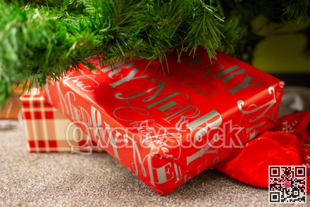 Christmas gifts laying underneath of fir tree branches.