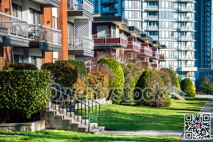 Facades of residential apartment buildings with doorsteps with lawn in front