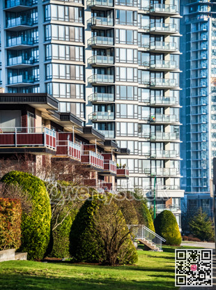 Facades of residential apartment buildings with doorsteps from lawn in front.