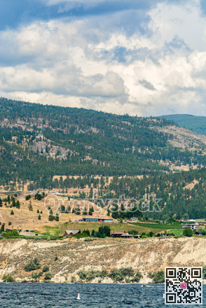 Overview of Okanagan lake with mountains and clouds background.