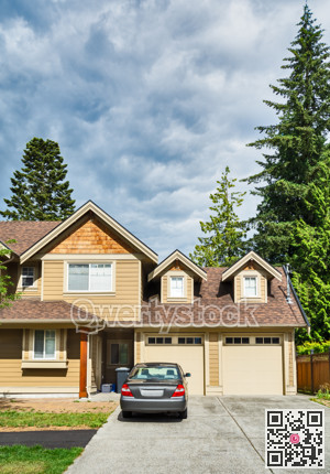 Luxury residential house with car parked in front on cloudy sky background