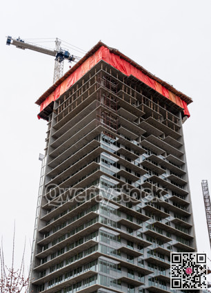 High rise monolith concrete building with the crane above