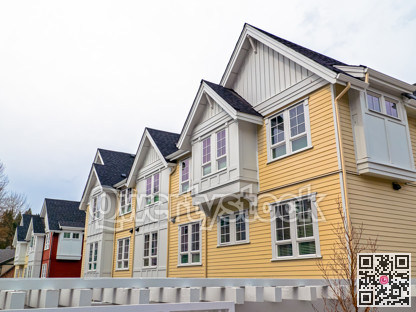 Top levels of residential townhouses on overcast sky backgfound