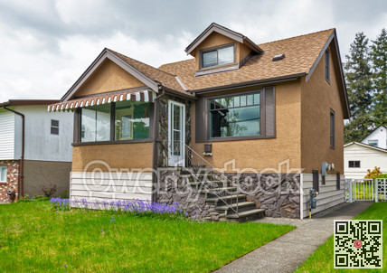 Modest family house with green lawn in front. Old residential house