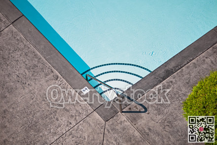 Corner of emerald swimming pool with steps leading to the deeper water