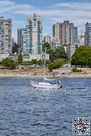A small boat in a body of water with a city in the background