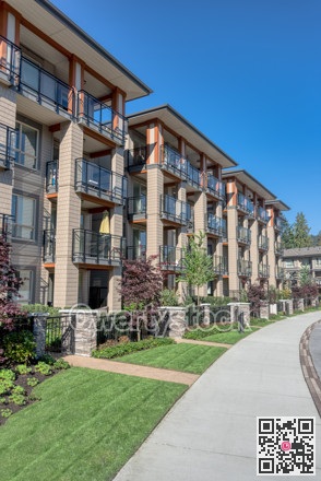 Paved pathway along residential building on sunny day