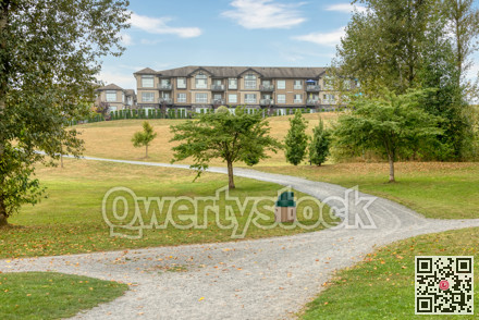 Gravel pathway in a park in front of residential building on the hill