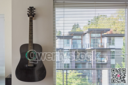 Living room window with guitar on the wall