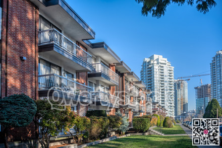 Residential apartment buildings with doorsteps from the green lawn in front.