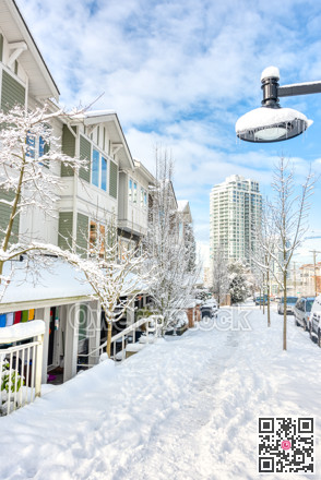 Residential townhouses and high-rise building on bright winter day