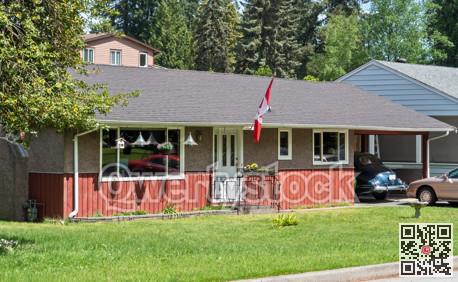 Average residential house with canadian flag and green lawn in front