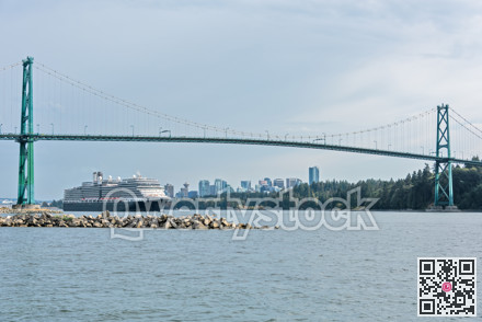 View of ocean harbor with huge ocean cruise liner passing Lion Gates Bridge