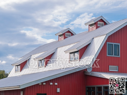 Top roof of new red barn on cloudy sky background