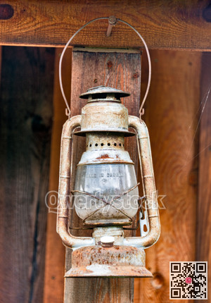 Old rusty oil-lamp under the summer wooden shed