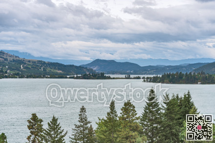 Kalamalka lake overview with mountatins and cloudy sky background