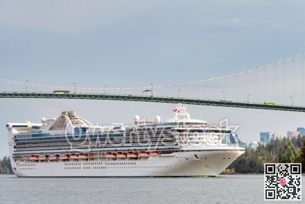 Huge white ocean cruise liner passing famous Lion Gates Bridge