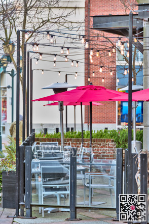 Unpopulated street cafe under red umbrellas on a winter season