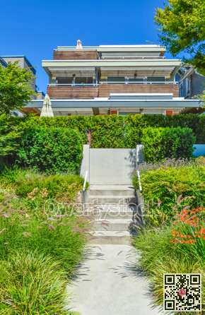 Concrete pathway over landscaped front yard to residential house