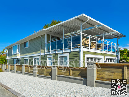 New residential house with wooden fence along a road