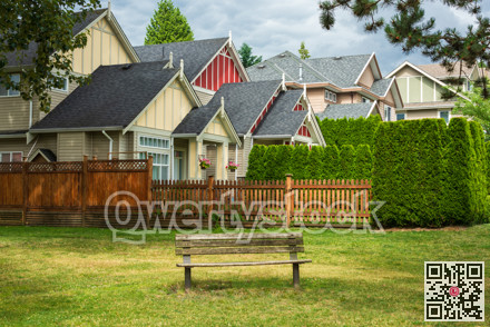 Old wooden bench in a park are in front of residential houses