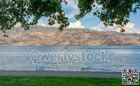 Overview of Okanagan lake with a boat and waterskiing man on the water