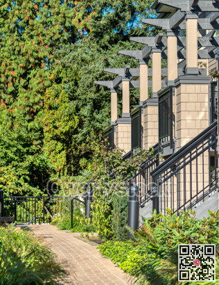 Porches of residential townhouses in a row with paved pathway in front