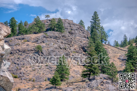View at rocky mountain slop on cloudy sky background