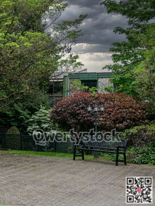 Small park with metal bench and street light in residential area