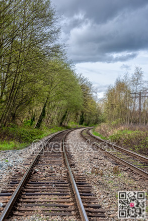 Curve of rail road pathways leading to a city