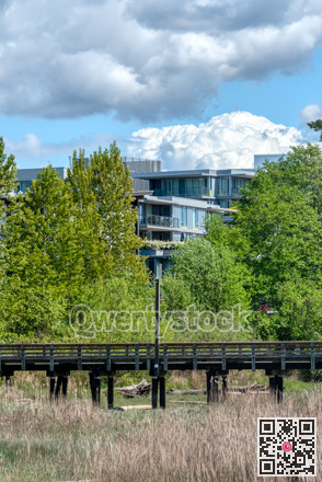 Eco cityscape. Wooden pier in front of residential building on clouds background