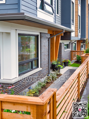 Wooden fence in front of new residential townhouse on foggy day