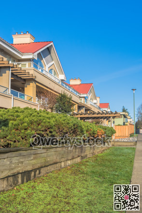 Residential building with red roofs and hedge row on land terrace