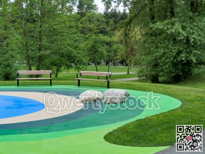 Recreational area in a park with two benches on colored ground