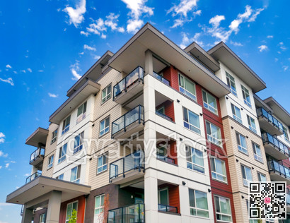 New low-rise residential building on blue and cloudy sky background