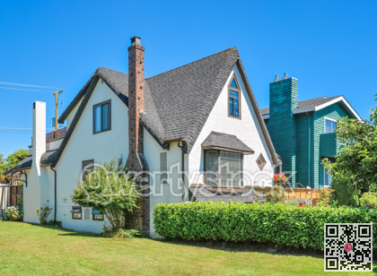 Old style family house with green lawn and hedgerow in front