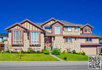 Luxury residential house with wide garage door on blue sky background