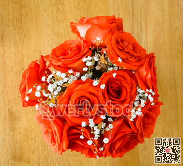 Beautiful bouquet of red roses on a wooden table