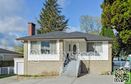 Average residential house with concrete stairs and paved front yard