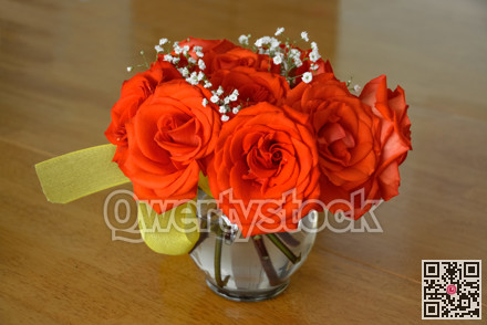 Beautiful bouquet of red roses on the wooden table