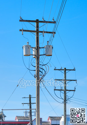 Wooden electricty pole with mounted transformators on blue sky background
