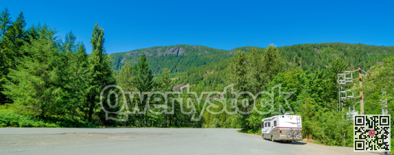 Luxury motorhome with bykes attached to the rack on a wide asphalt road