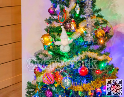 Decorated Christmas tree on white wall background in the corner of the room