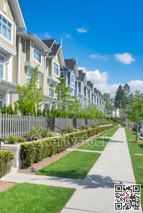 Paved walkway in front of residential townhouses on a bright sunny day