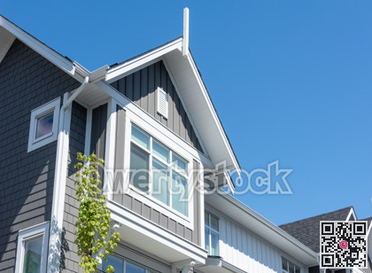 Top of residential townhouse on blue sky background