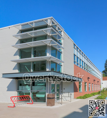 Office building with concrete pathway in front and blue sky background